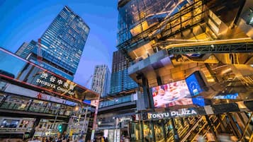 A modern urban area with high-rise buildings, including a prominent glass structure with signage for 'SHIBUYA CHUO-GAI' and 'TOKYU PLAZA'.