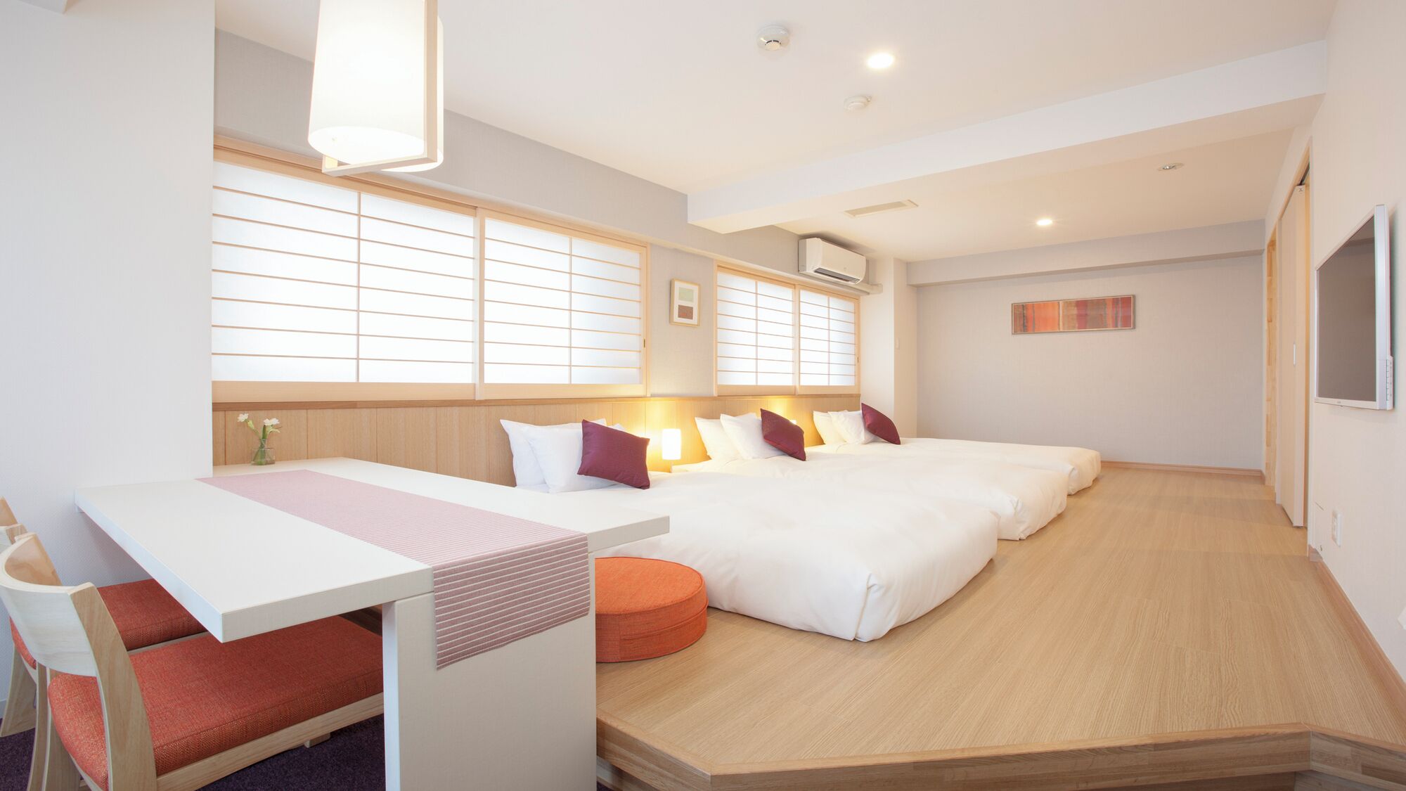 A hotel room with a bed, bedside tables, a desk, and a chair.