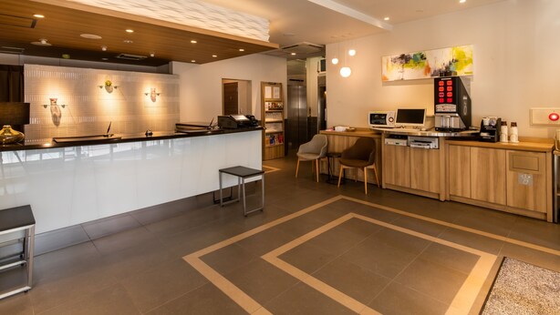 A modern kitchen with a central island, a coffee machine, and a seating area with two chairs. - Tokyu Stay Monzen Nakacho Tokyo (Tokyo)
