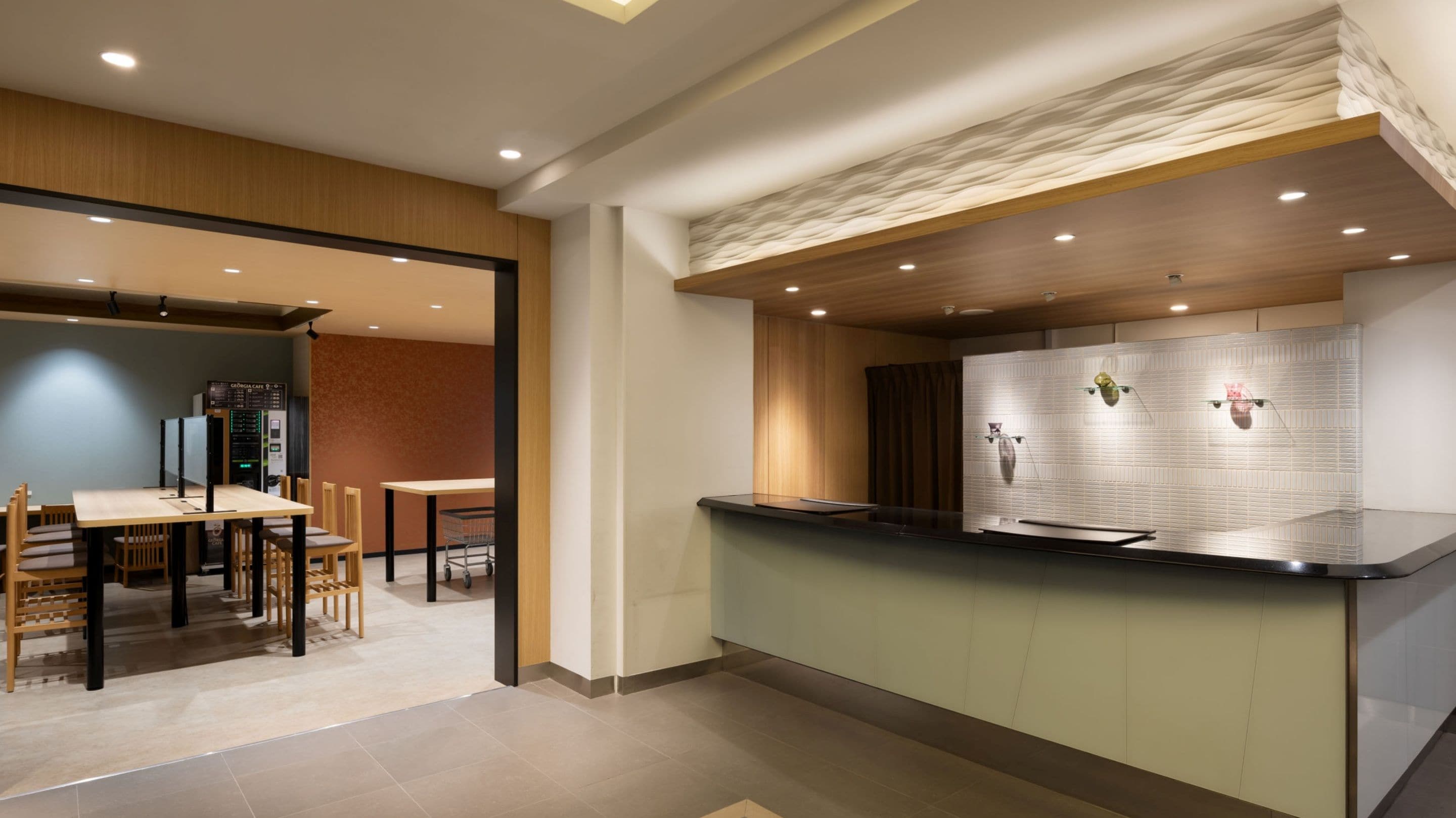 Una cocina moderna con encimera, armarios de madera y un área de comedor con sillas y una mesa.