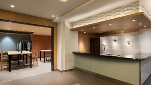 A modern kitchen with a countertop, wooden cabinets, and a dining area with chairs and a table. - Tokyu Stay Monzen Nakacho Tokyo (Tokyo)
