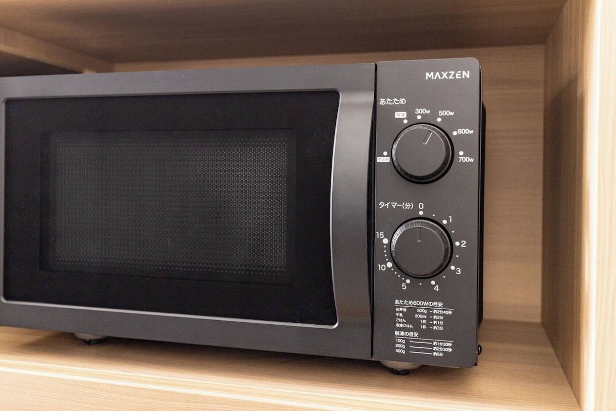 Un horno microondas MAXZEN con pantalla digital, ajustes de potencia y controles de temporizador.
