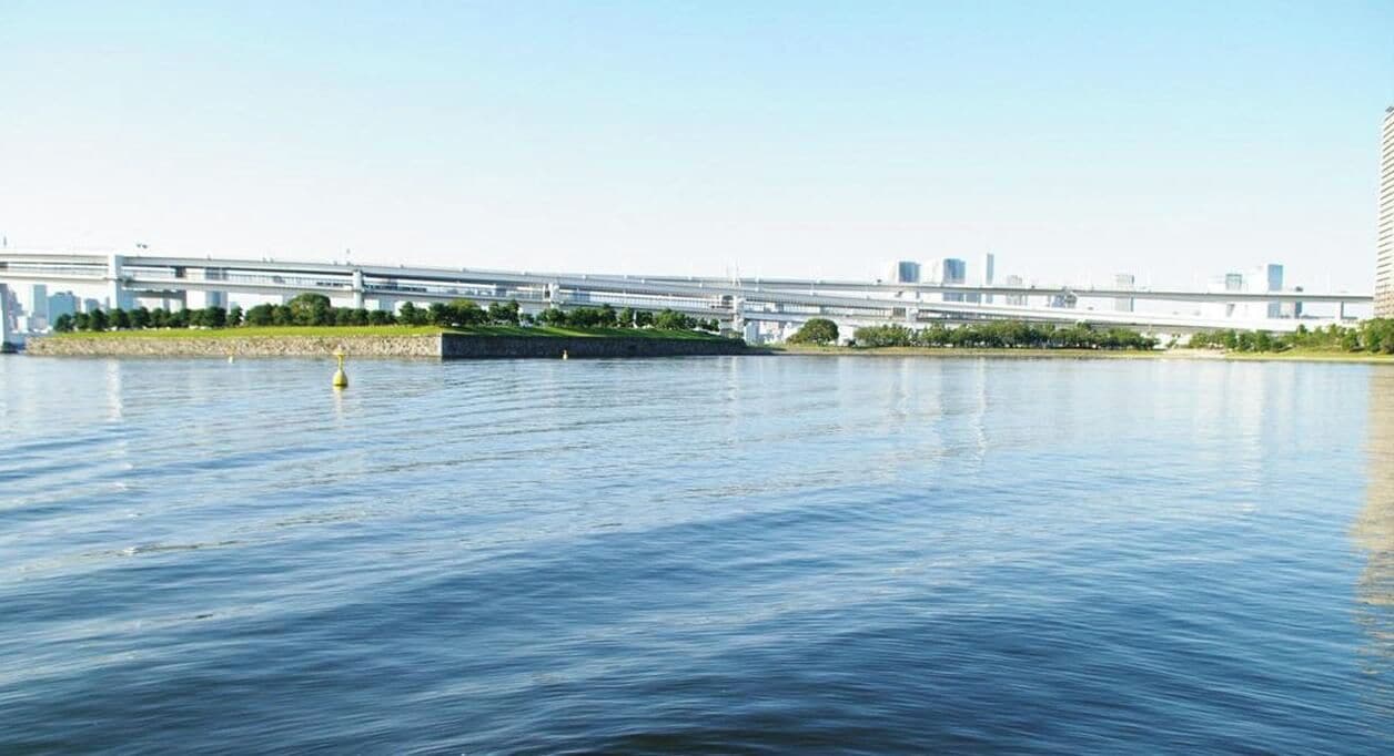 Une rivière avec un pont et des bâtiments en arrière-plan.