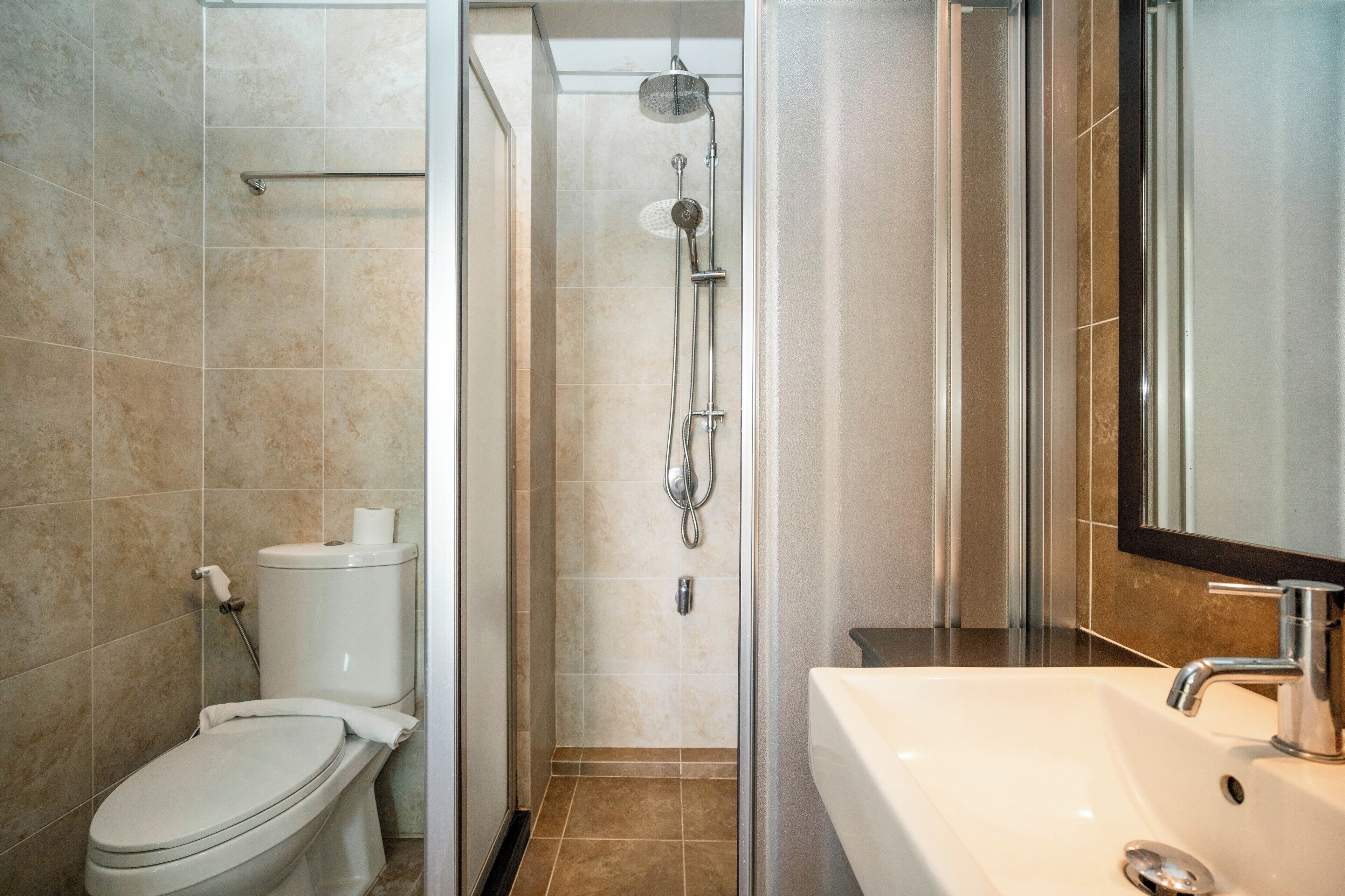 A modern bathroom with a toilet, shower, and sink.