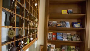 A room with a key rack and a bookshelf filled with books. - Ganfo (Sirmione)
