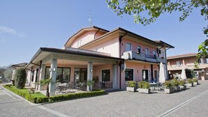 A two-story building with a covered outdoor seating area and a bar. - Ganfo (Sirmione)