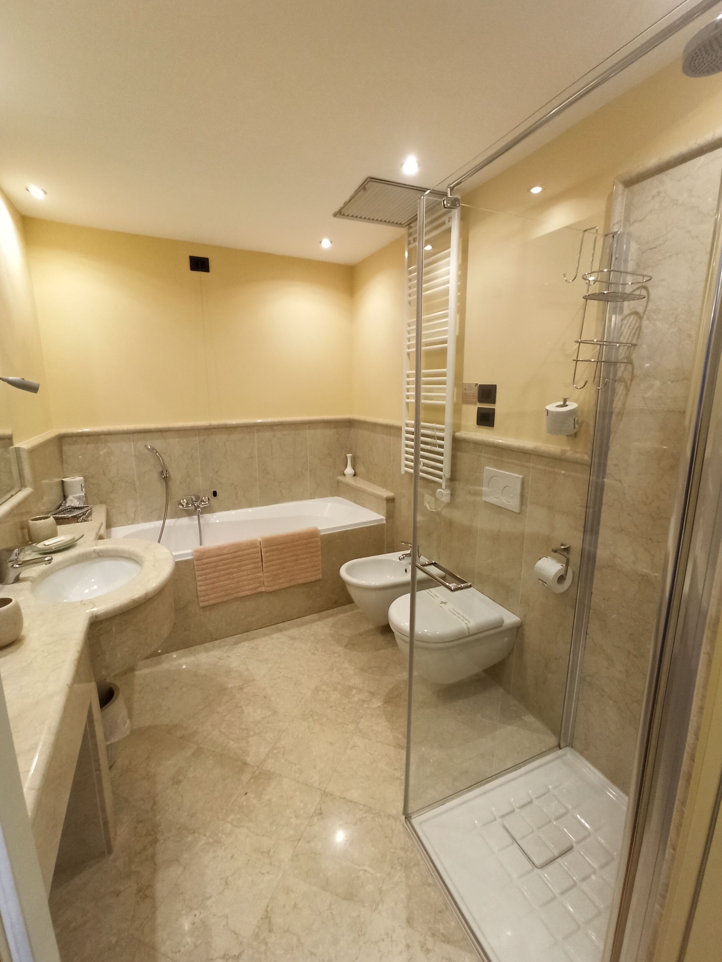 Un baño moderno con bañera, dos lavamanos, ducha e inodoro.
