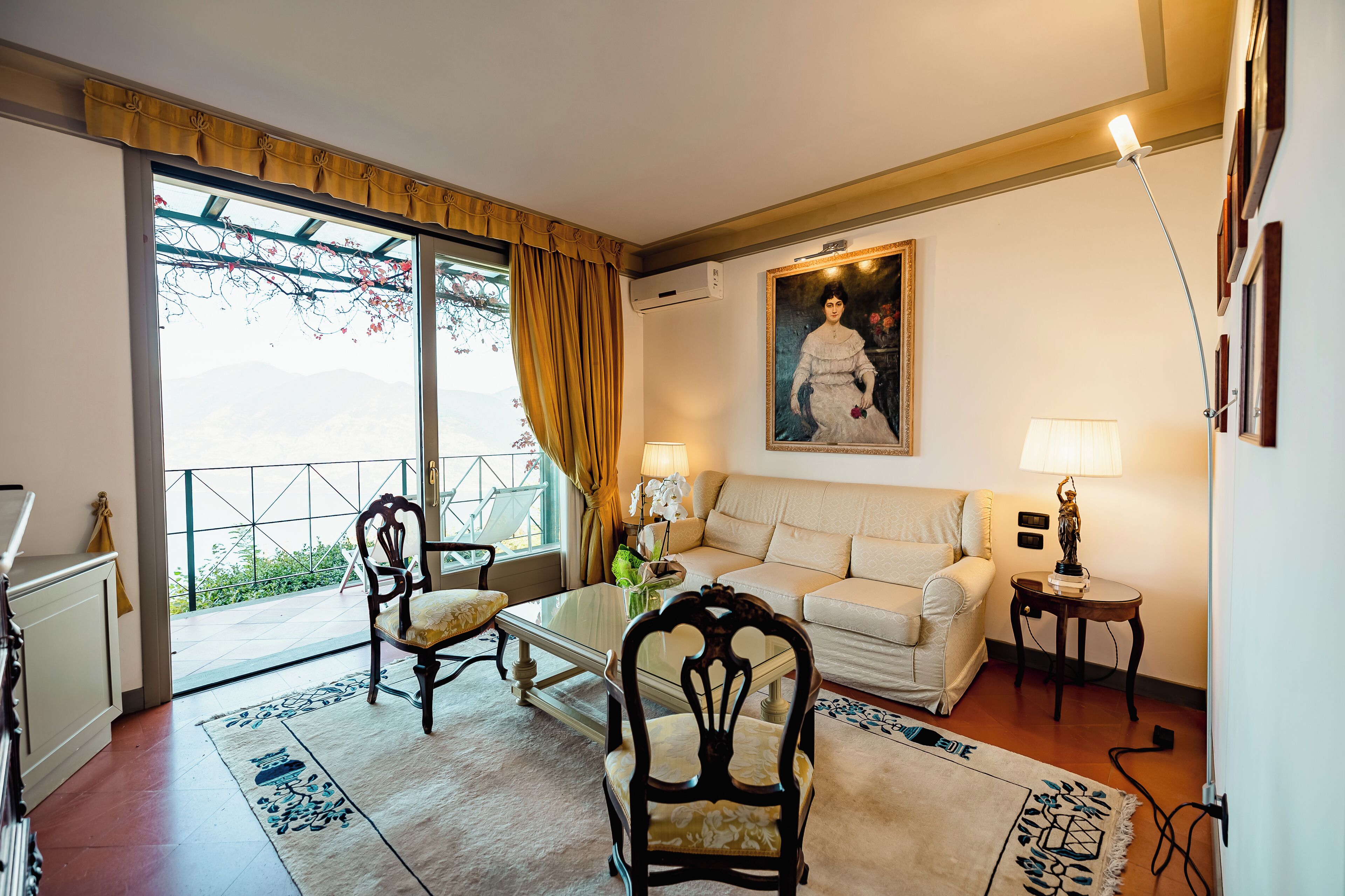 A living room with a sofa, chairs, a coffee table, and a painting on the wall.