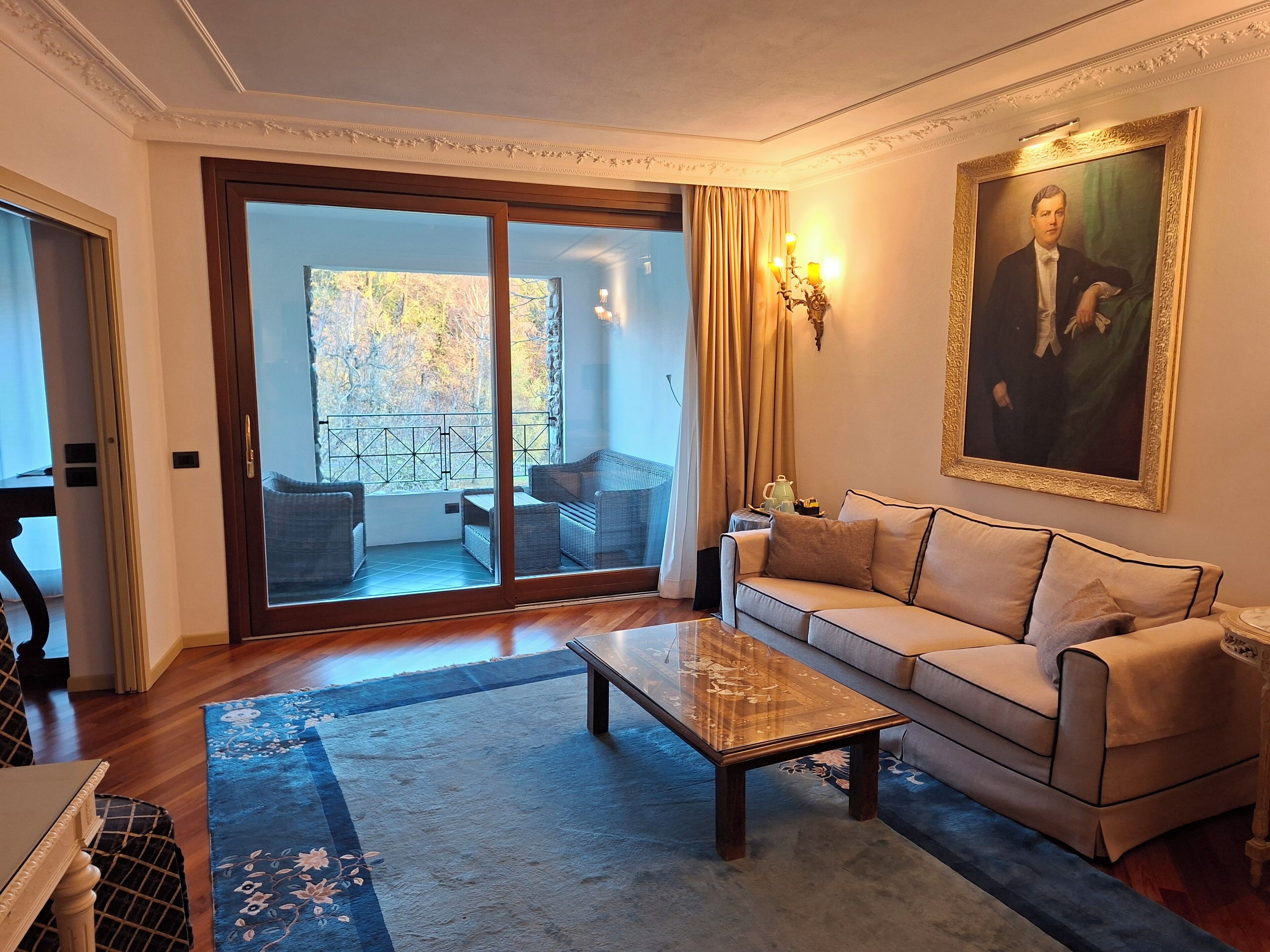 A living room with a sofa, a coffee table, and a painting on the wall.