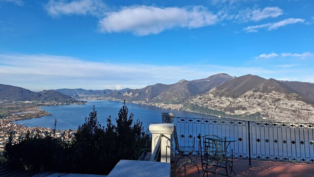 A terrace with a view of a lake and mountains.