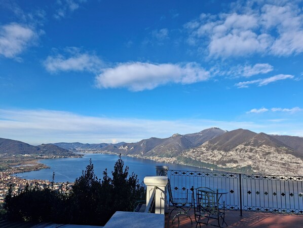 A terrace with a view of a lake and mountains.