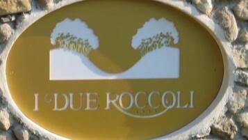 En skylt med texten ”I DUE ROCCOLI” och en illustration av två träd.