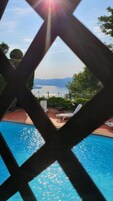 Una piscina al aire libre de temporada, sombrillas, tumbonas
