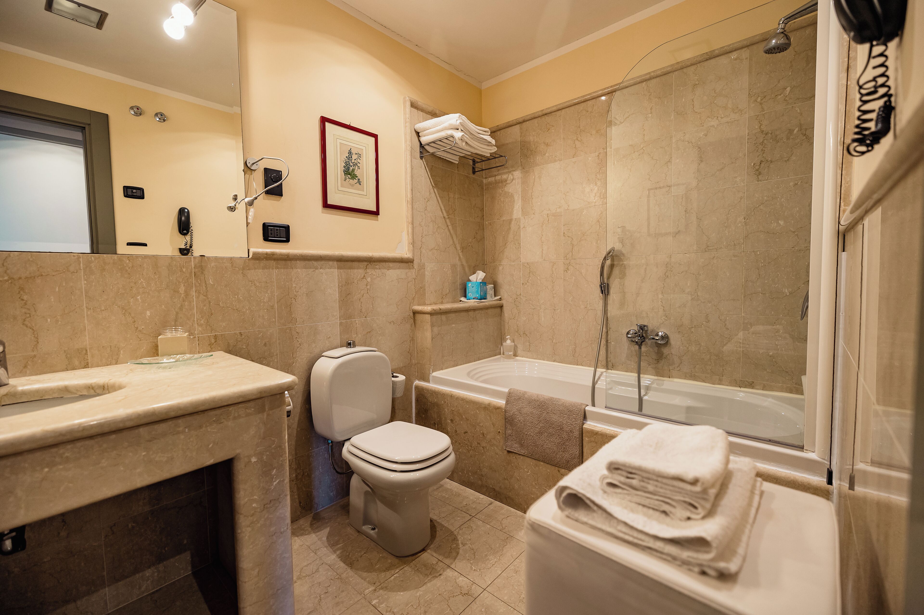 Ein Badezimmer mit Toilette, Waschbecken, Badewanne und Dusche.