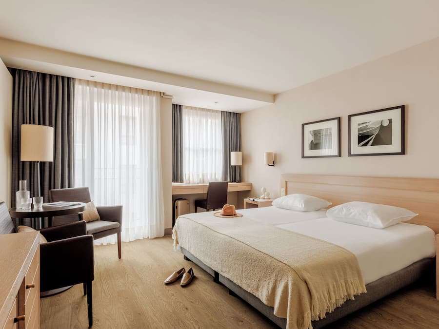 Une chambre d’hôtel équipée d’un lit, d’un bureau, d’une chaise et d’une table à manger.