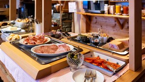 Un buffet proposant une variété de plats, notamment des viandes, des fromages et des légumes.