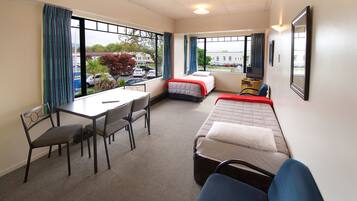 A hotel room with a bed, a desk, and a chair.