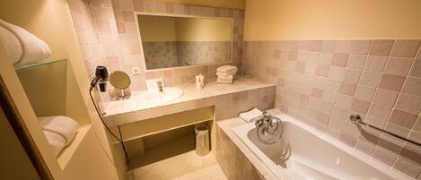 A bathroom with a bathtub, a sink, a mirror, and a towel rack.
