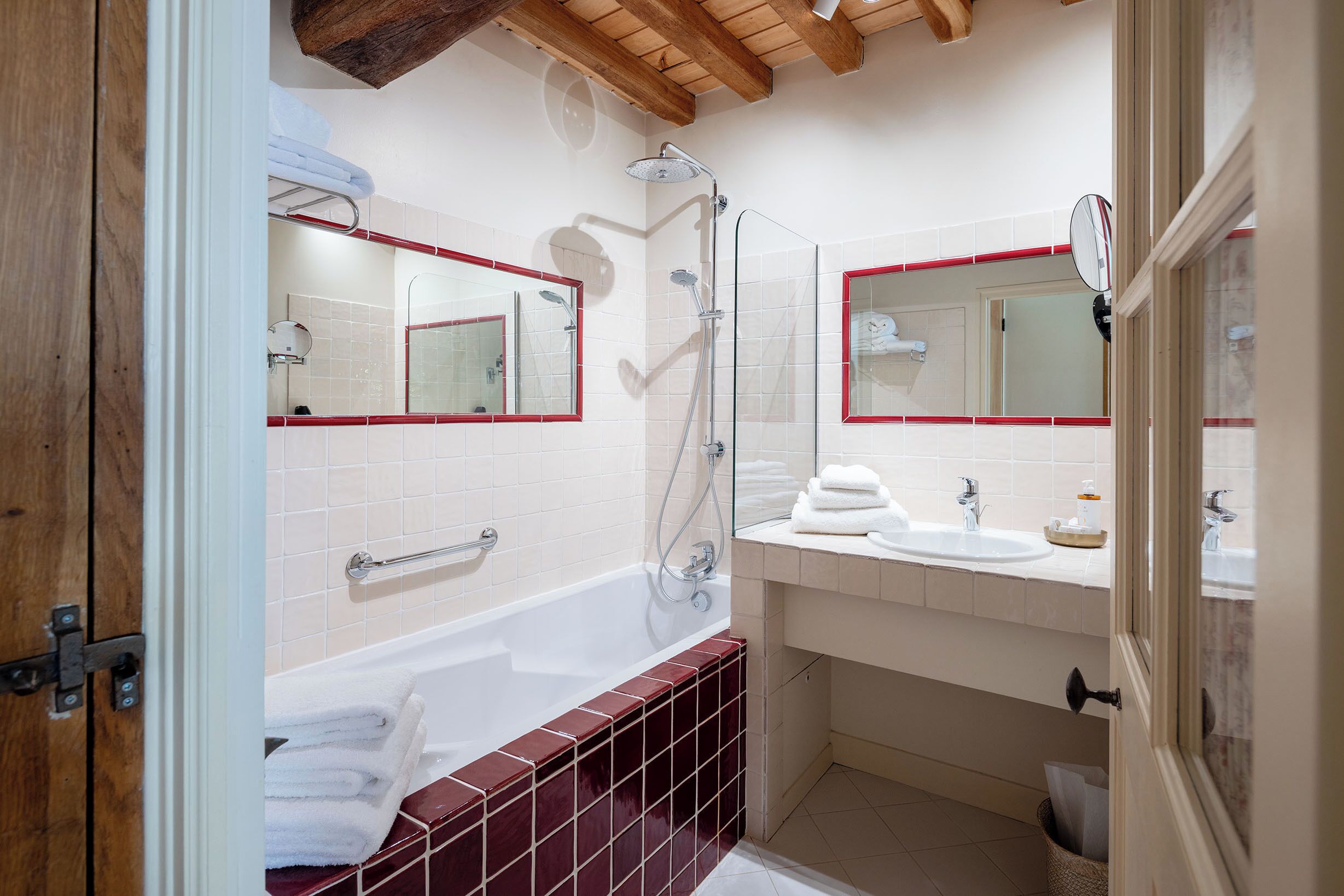 A modern bathroom with a bathtub, a shower, and a vanity with a mirror.