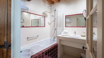 A modern bathroom with a bathtub, a shower, and a vanity with a mirror.