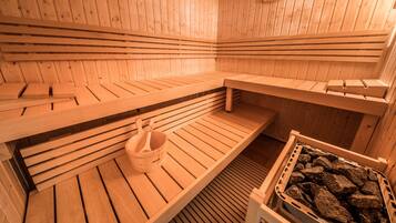 Een sauna met houten banken en een baksteen gevuld bassin.
