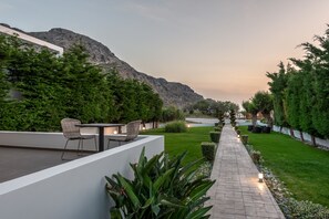 Un patio moderno al aire libre con zona de estar, un sendero y vistas a la montaña.