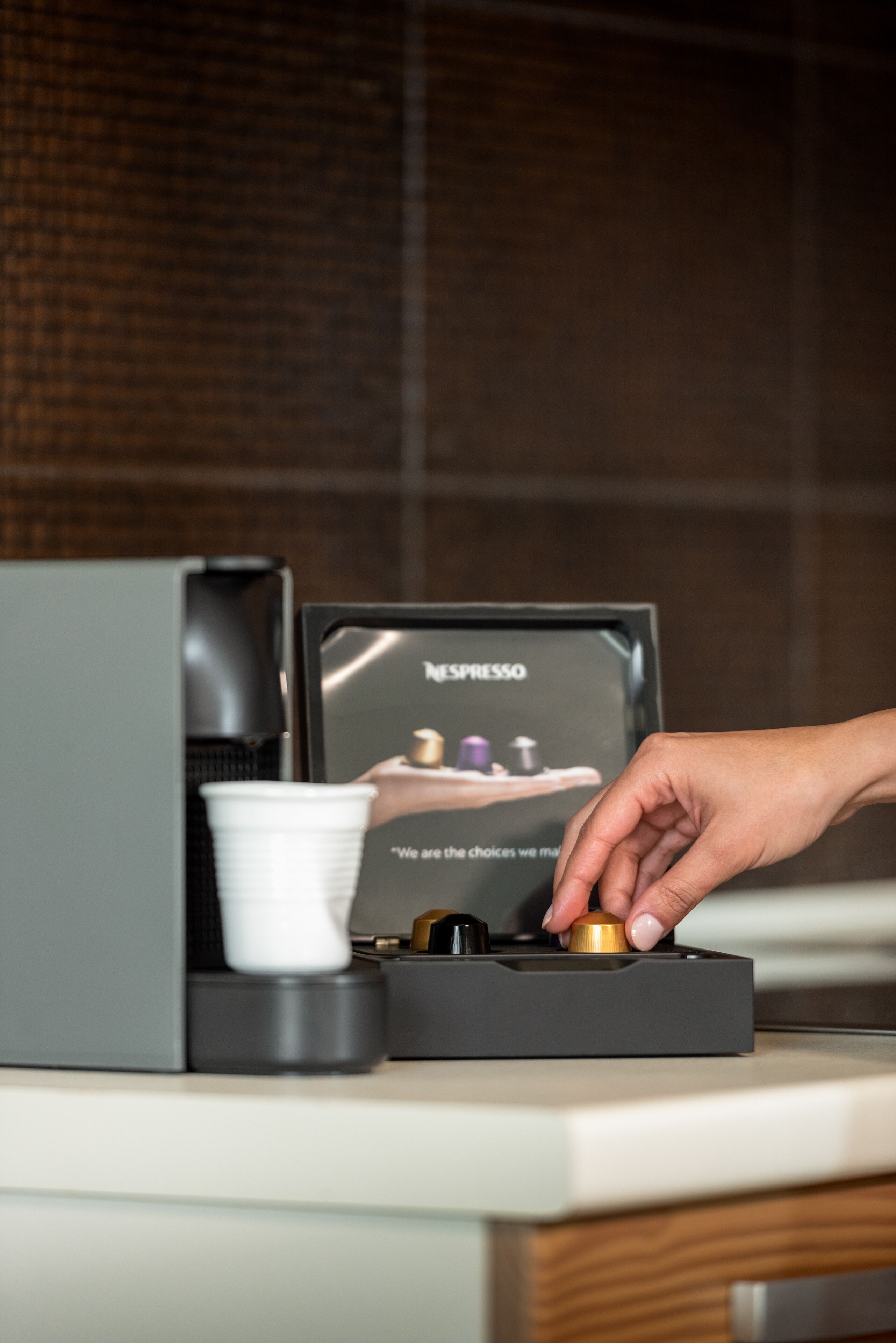 A coffee machine with a cup and a display of coffee pods.