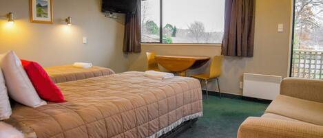 A hotel room with two beds, a desk, and a chair.