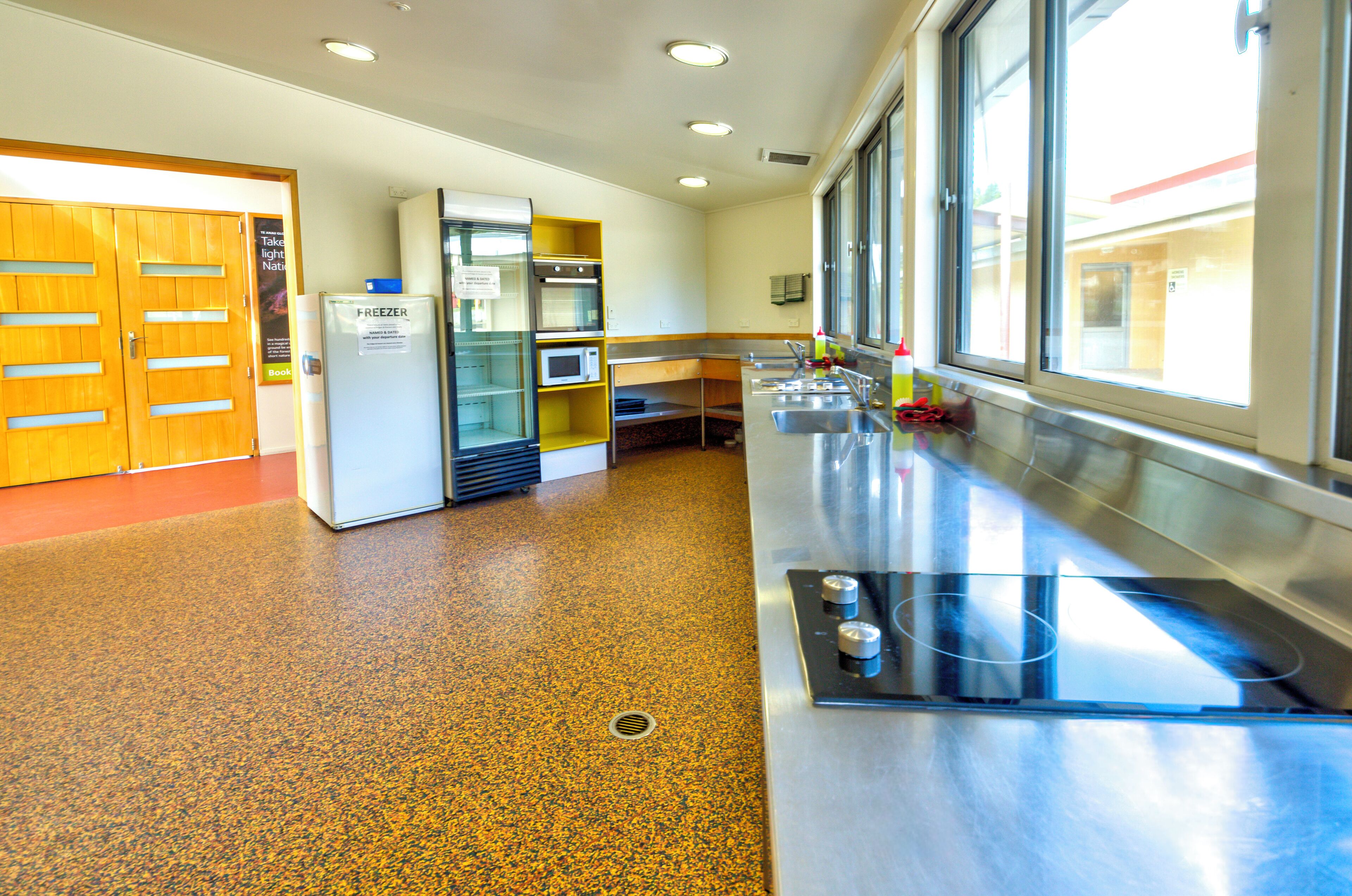 A kitchen with a refrigerator, microwave, and sink.