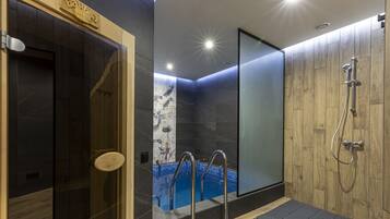Bathroom features a glass-enclosed shower with a wooden panel design and a handheld shower attachment.