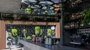 A modern bar with a hexagonal wall design, bar stools, and a coffee machine. - Park House Hotel (Kryvyi Rih)