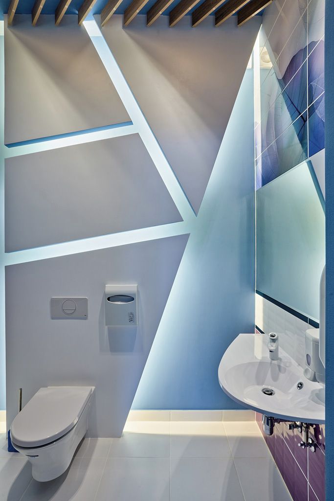 A modern bathroom with a toilet, a sink, and a hand dryer.
