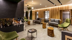 A modern lobby with a reception desk, green chairs, sofas, and a wooden accent wall. - Park House Hotel (Kryvyi Rih)