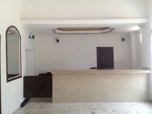 Una habitació amb un mirall gran, una porta fosca i una superfície de color clar.