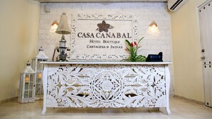 Una mesa de recepción con un cartel que dice "CASA CANABAL HOTEL BOUTIQUE CARTAGENA B INDÍAS".