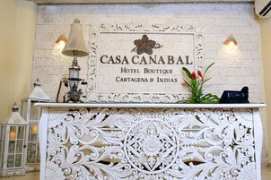 Un comptoir d'accueil avec une enseigne indiquant : « CASA CANABAL HOTEL BOUTIQUE CARTAGENA B INDIAS ».