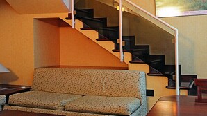 A staircase with a handrail, a sofa, and a painting on the wall. - Residence Lagrange (Turin)