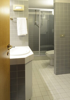 Un baño con lavamanos, inodoro y ducha.