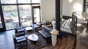 Un interior moderno con un sofá, sillas, una mesa de centro y un jarrón decorativo.