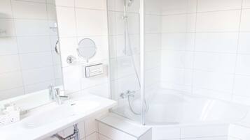 Ein modernes Badezimmer mit Waschbecken, Spiegel und einer Duschkabine.