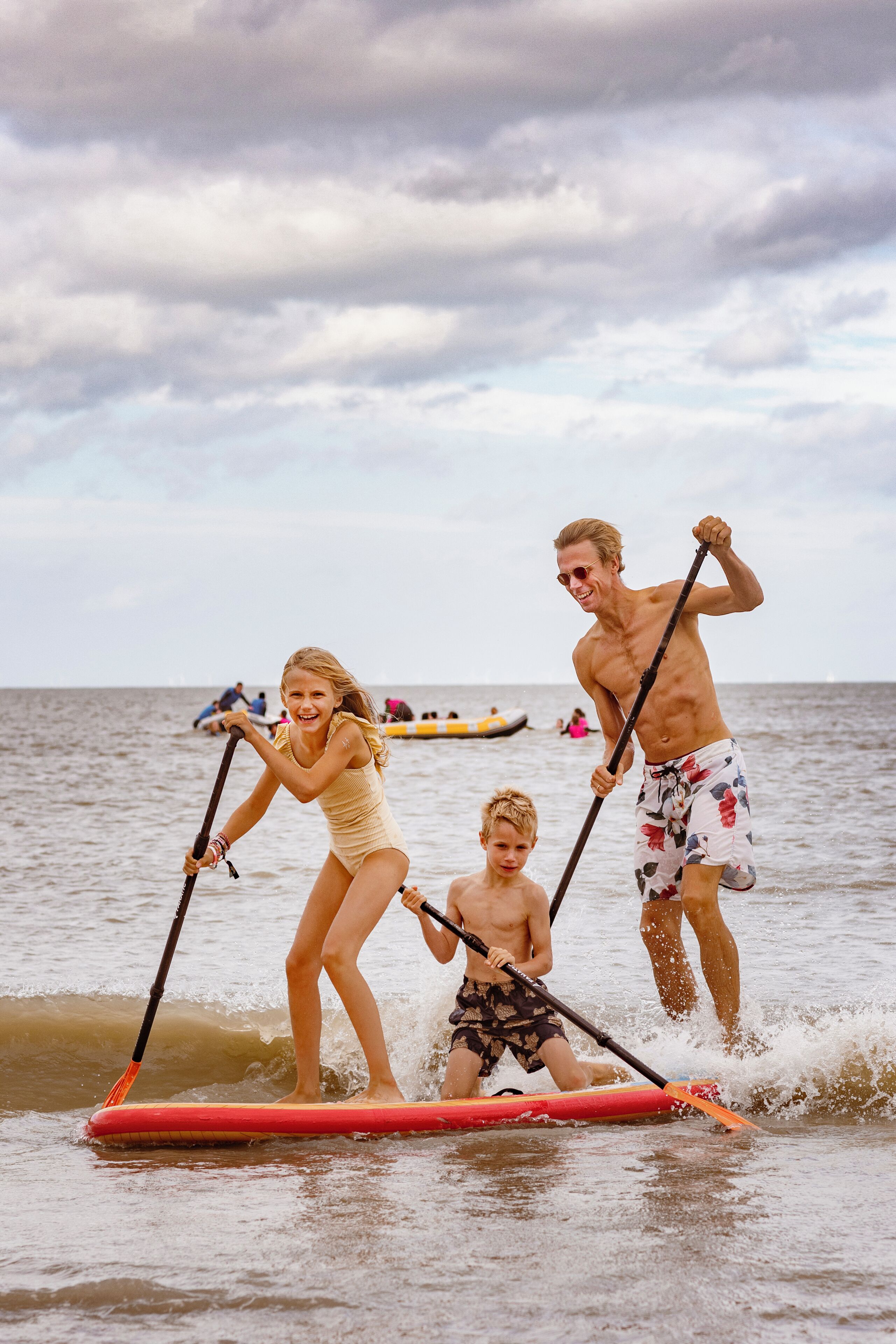 A group of people on a paddleboard in the water.