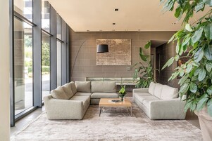 Una sala moderna con un sofá seccional, una mesa de centro y un ventanal que proporciona luz natural.