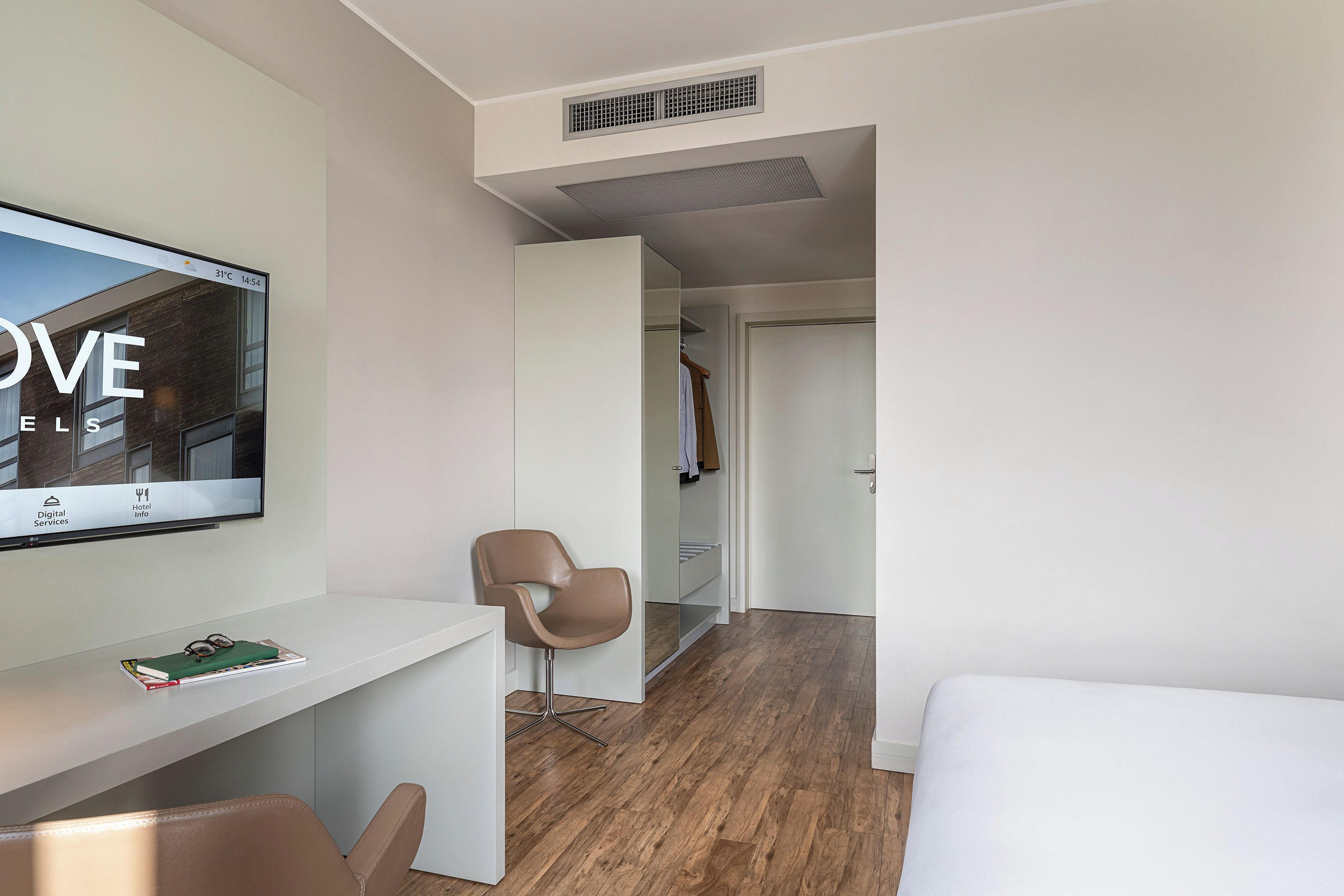 Una camera d'albergo moderna con una scrivania, una sedia e un letto.