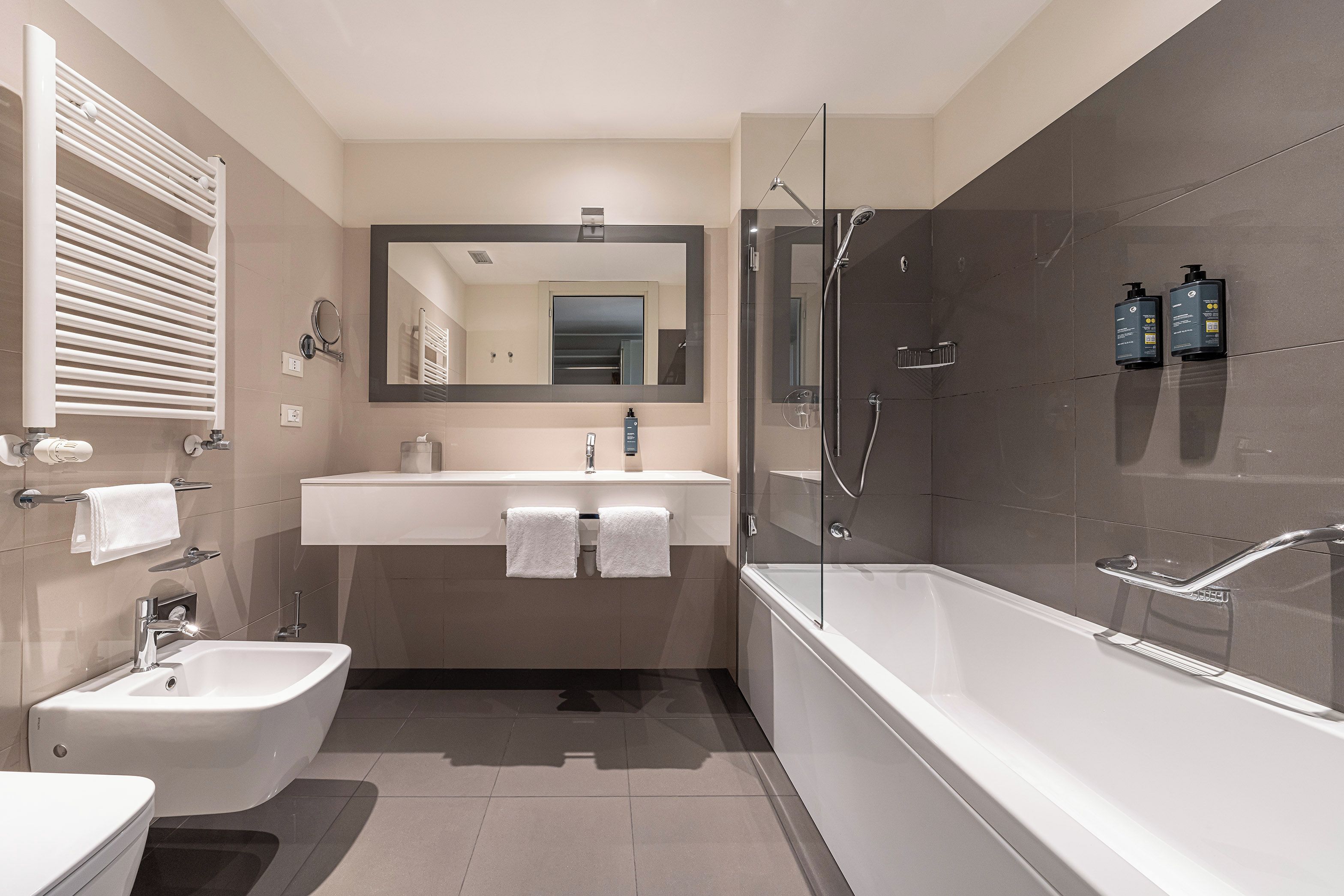 Ein modernes Badezimmer mit integriertem Bidet, einer Badewanne und einer Duschkabine.