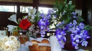 Een tafel met bananen, druiven, een mand en een vaas met bloemen.