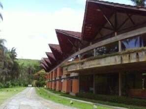 A building with a curved roof and a pathway leading to it. - Hotel Cupim Lazer (CRISTIANO OTONI)