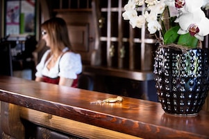 Una barra de madera con un jarrón decorativo de flores blancas.