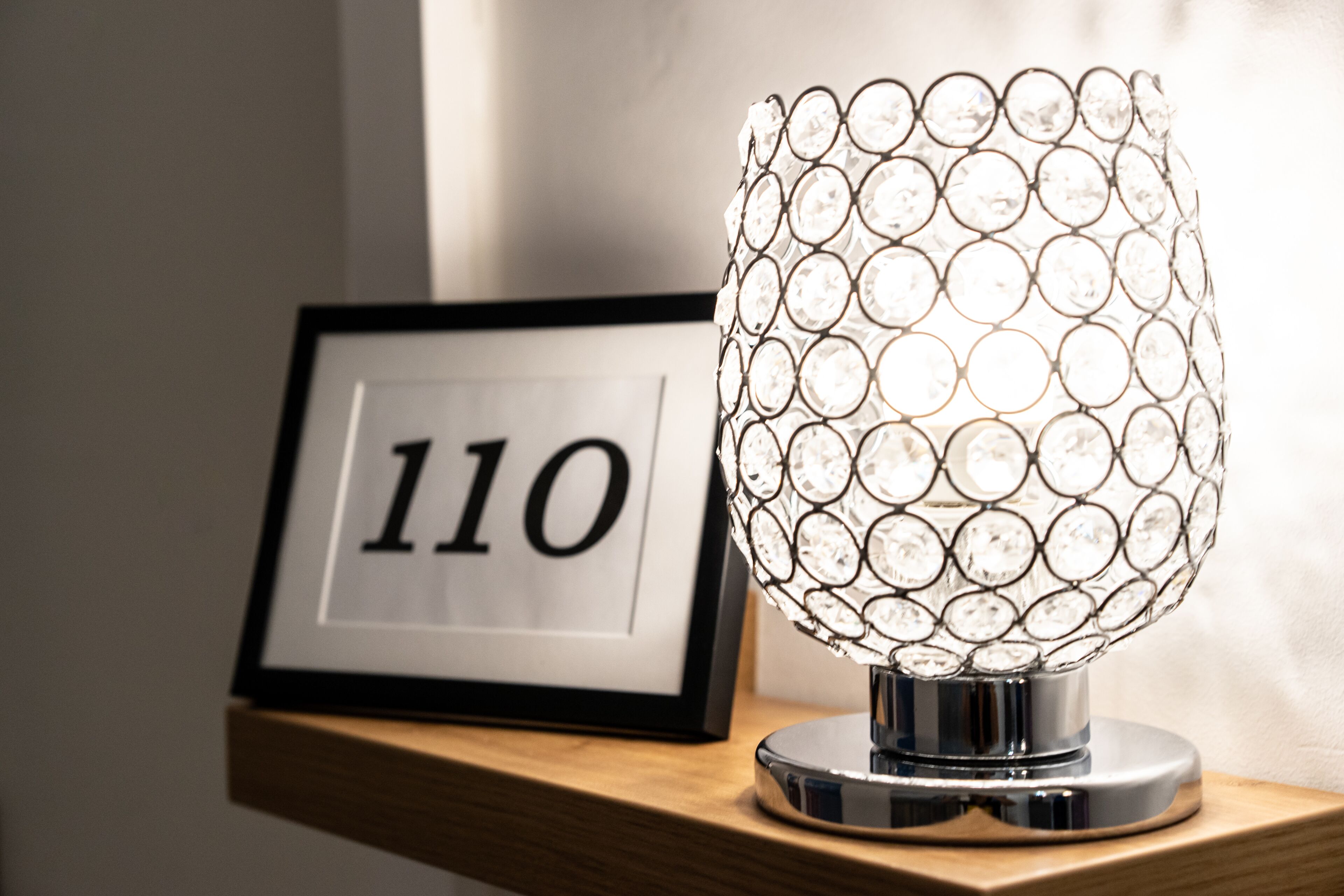 Een decoratieve lamp met een helder, bolvormig ontwerp op een houten ondergrond.