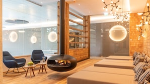 Un área de estar moderna con chimenea, sofás y un revestimiento de madera.