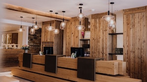 Un área de recepción con paneles de madera, un mostrador de recepción e iluminación colgante.